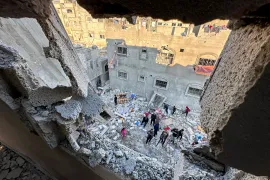 Palestinians stand amid the rubble after an Israeli attack on a house in Rafah, southern Gaza, on December 29, 2023 [Fadi Shana/Reuters]