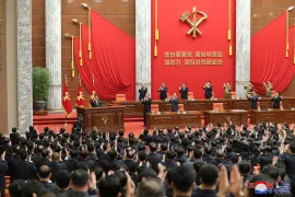 Kim Jong Un acknowledges the applause of party delegates and officials [KCNA via KNS and AFP]