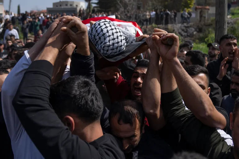 Mourners carry the body of Palestinian Mohammed Saleem, 15 during his funeral in the West Bank village of Azzoun, near Qalqiliya