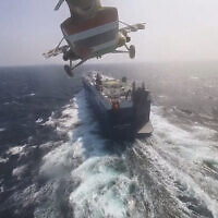 This photo released by the Houthi Media Center shows a Houthi forces helicopter approaching the cargo ship Galaxy Leader on November 19, 2023. Yemen's Houthis have seized the ship in the Red Sea off the coast of Yemen after threatening to seize all vessels owned by Israeli companies. (Houthi Media Center via AP)