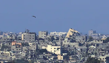 A bird flies over damaged buildings in Gaza, amid the ongoing conflict between Israel and the Palestinian Islamist group Hamas, as seen from southern Israel, on Tuesday.