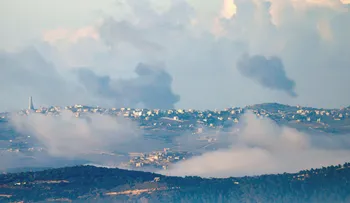 A picture taken from a position along the border in northern Israel shows black smoke billowing across the horizon along the hills in the southern Lebanese village of Meiss El-Jabal following Israeli bombardment on December 25, 2023, amid ongoing cross-border tensions as fighting continues between Israel and Hamas militants in Gaza. (Photo by jalaa marey / AFP)
