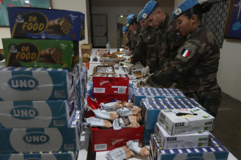 U.N French peacekeepers prepare cakes and other sweets during a Christmas party, at Saint-Joseph des Saints-Coeurs School in Ain Ebel, a Lebanese Christian border village with Israel, in south Lebanon, on Saturday, Dec. 23, 2023. Christians in the border villages of south Lebanon prepared for a subdued Christmas under the shadow of the ongoing war in Gaza and its spillover in Lebanon. (AP Photo/Mohammed Zaatari)