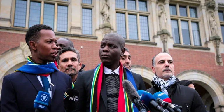 South Africa's Minister of Justice and Correctional Services Ronald Lamola, center, and Palestinian assistant Minister of Multilateral Affairs Ammar Hijazi, right, address the media outside the International Court of Justice in The Hague, Netherlands, Thursday, Jan. 11, 2024. The United Nations' top court opens hearings Thursday into South Africa's allegation that Israel's war with Hamas amounts to genocide against Palestinians, a claim that Israel strongly denies. (AP Photo/Patrick Post)