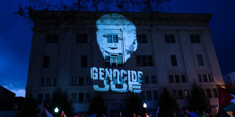 WASHINGTON, DISTRICT OF COLUMBIA, UNITED STATES - 2023/12/31: A projected picture of president Joe Biden with the text reading "Genocide Joe" on the wall of the African American Civil War Memorial Museum during in a Pro-Palestinian demonstation in Washington DC. Pro-Palestinian demonstrators gather at Thomas Circle and then hold a rally with Palestinian flags and banners, calling for a ceasefire in Gaza. (Photo by Probal Rashid/LightRocket via Getty Images)