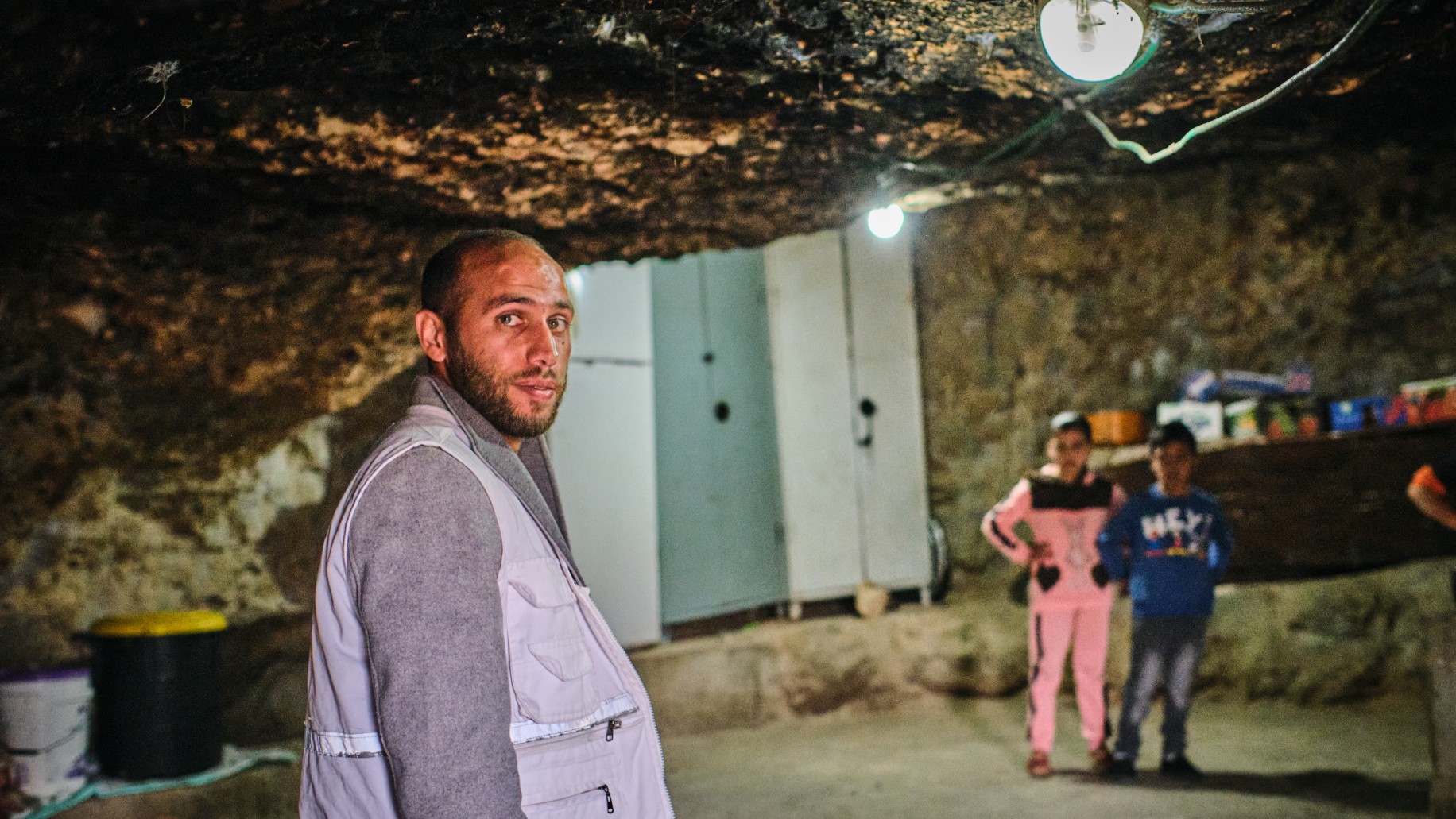 A doctor from the Palestinian Medical Relief Society distributes medicine at one of the caves near the village of Halaweh, where Bedouins are taking shelter (MEE/Angelo Calianno)