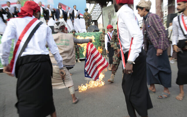 Houthi supporters burn the American flag during a rally to mark the seventh anniversary of the Houthis' takeover of the Yemeni capital, in Sanaa, Yemen, September 21, 2021. (AP Photo/Hani Mohammed, File)