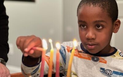 Jack Kulbersh lights a menorah (Courtesy: Project Menorah)