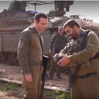 Maj. Idan (right), deputy commander of the Givati Brigade's Rotem Battalion, returns a wallet and dog tag that Yedid Ackerman (left) lost during the 2014 Israel Hamas war (Ynet video screenshot; used in accordance with Clause 27a of the Copyright Law)