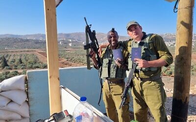 IDF soldiers with Koren Jerusalem's special wartime edition of the Book of Genesis, in an undated photo. (courtesy)