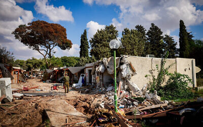 Israeli soldiers survey the destruction caused by Hamas terrorists in Kibbutz Kfar Aza, near the Israel-Gaza border, in southern Israel, October 15, 2023. (Chaim Goldberg/Flash90)