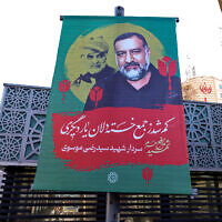 A memorial poster for Razi Moussavi, a senior commander in the Quds Force of Iran's Islamic Revolutionary Guard Corps (IRGC) who was killed on December 25 in an Israeli strike in Syria, hangs along a street in Tehran on December 27, 2023. (ATTA KENARE/AFP)