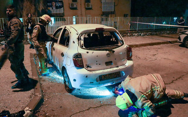 Officials inspect damage after a rocket fired from Lebanon hit the northern town of Kiryat Shmona, December 27, 2023. (Ayal Margolin/Flash90)