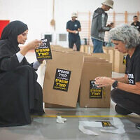 Two women work together at a volunteer center in Rahat, Israel, run by Jewish and Arab volunteers. (Facebook, used in accordance with clause 27a of the copyright law)