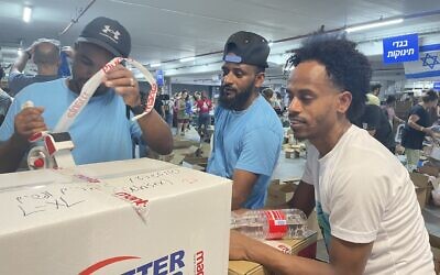 Eritrean asylum seekers volunteer at the Civilian Operations Hub, Expo Tel Aviv, October 19, 2023. (Sue Surkes/Times of Israel)