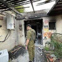 An IDF serviceman stands outside a destroyed home in the Gaza border community of Kfar Aza on December 20, 2023. (Sam Sokol)
